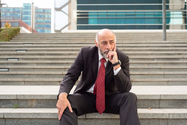 Upset businessman sitting in steps