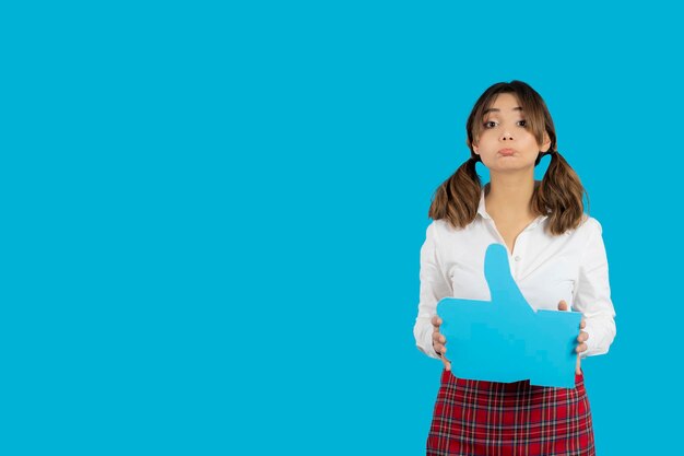 Upset college girl holding blue like sign. High quality photo