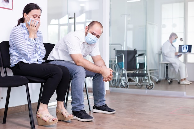 Upset couple in hospital waiting room after bad news from medical stuff