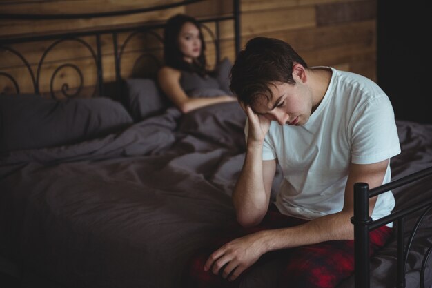 Upset couple ignoring each other after fight on bed