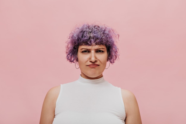 Foto gratuita donna dai capelli ricci sconvolta con taglio di capelli corto in abiti leggeri. signora alla moda in posa.