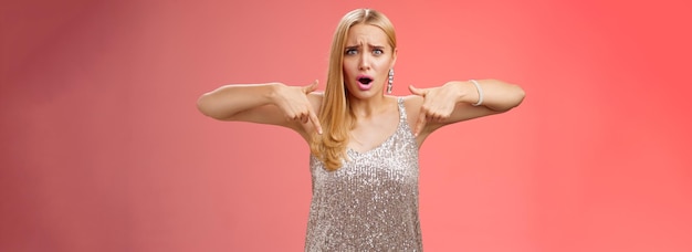 Free photo upset disappointed fooled blond elegant girlfriend in silver dress frowning grimacing bothered
