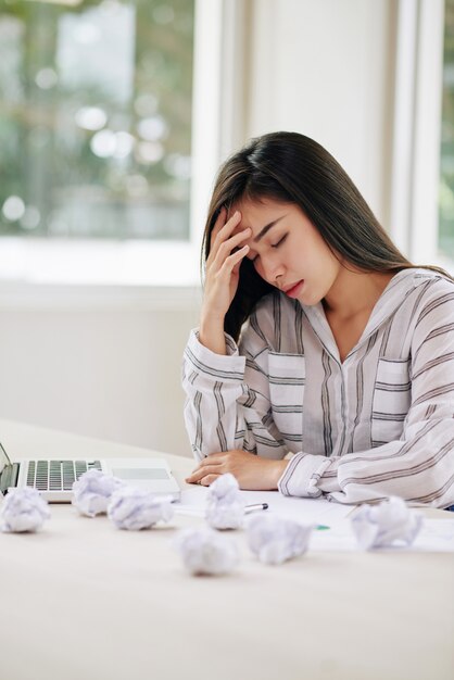 Upset ethnic woman writing papers