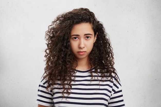 Upset female has crisp hair, sullen or gloomy expression, being displeased