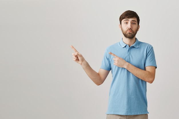 Upset and gloomy young bearded man posing