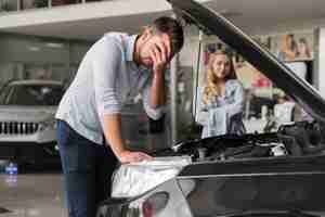 Foto gratuita uomo turbato che controlla il motore di automobile