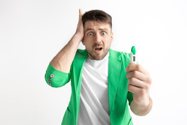 Upset man looking in pregnancy test.