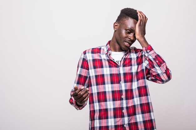 Upset and sad african man grabbing his forehead with hand standing missing the diversity lottery application deadline or forgetting to turn of electricity at home.