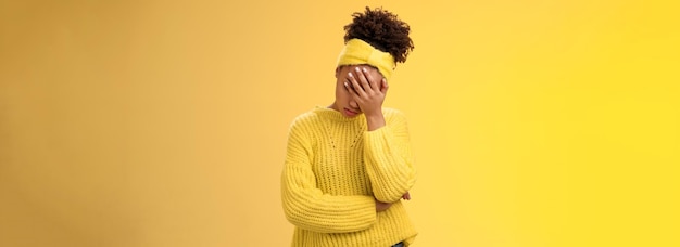 Бесплатное фото Расстроенная усталая афроамериканка-предпринимательница, склонившая голову на лицо, закрывающая глаза, прижав ладонь к лицу