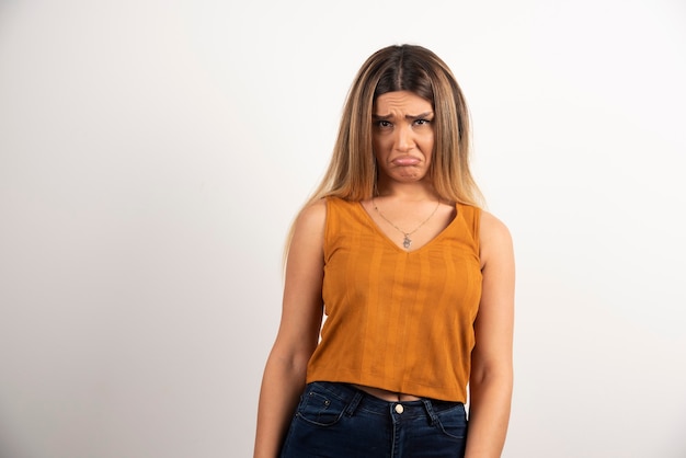 Upset woman posing on white background.