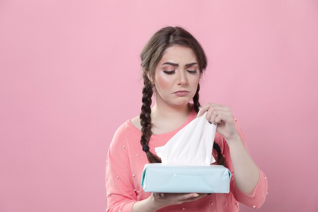 Upset woman taking out napkin from box with copy space