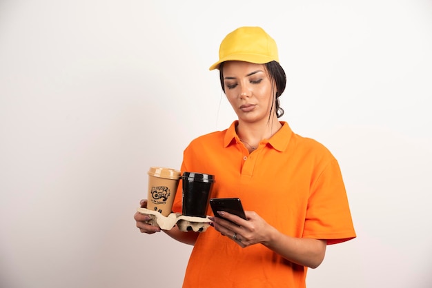 Free photo upset woman with cups looking on phone