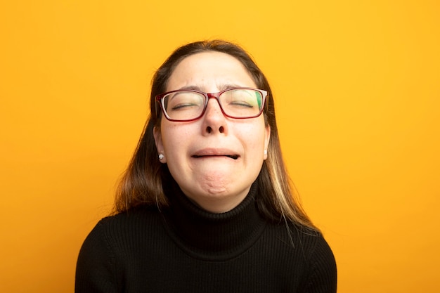 Upset young beautiful girl in a black turtleneck crying 