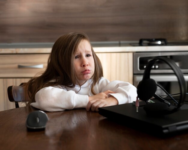 Расстроенная молодая девушка с ноутбуком и наушниками