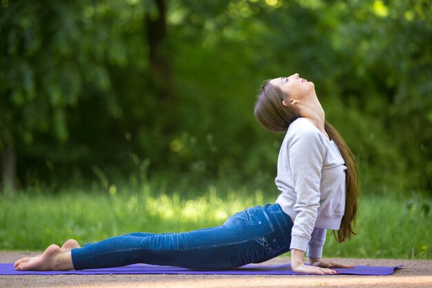 Upward facing dog pose in park alley