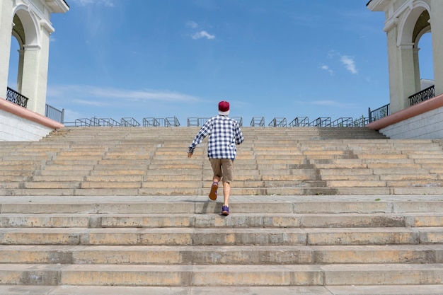 Городская концепция, молодой человек шел по лестнице в городе Premium Фотографии