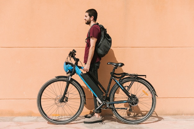 Urban cyclist standing next to e-bike