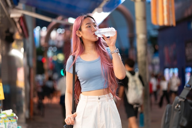 Urban portrait of young woman with long pink hair