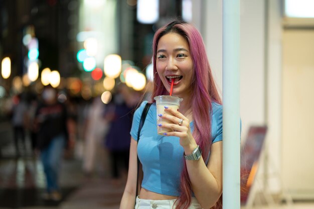 Urban portrait of young woman with long pink hair