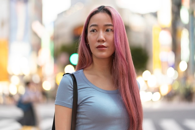 Городской портрет молодой женщины с розовыми волосами