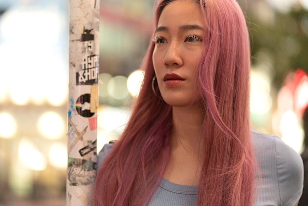 Urban portrait of young woman with pink hair