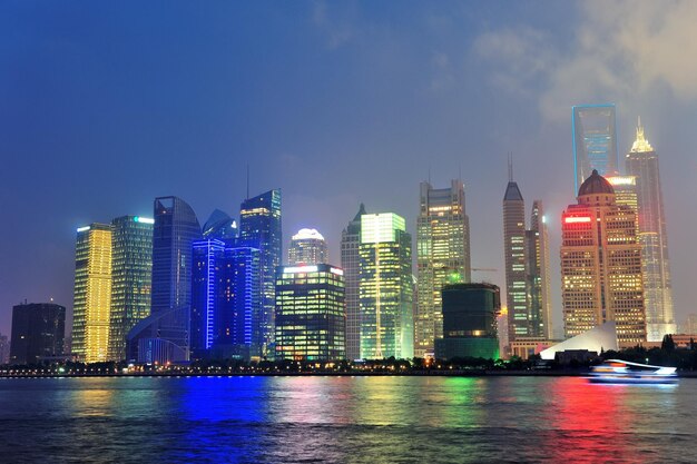 Urban skyscrapers in Shanghai at night over river