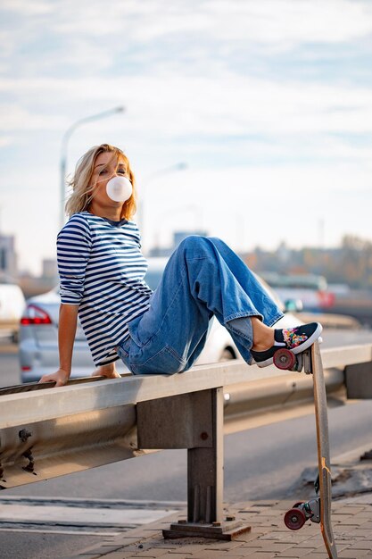 Urban stylish young girl walking with skateboard. Outdoors portrait of active sport woman model. Healthy lifestyle. Extreme sports. Fashion look, outdoor hipster portrait. Close up portrait of a prett