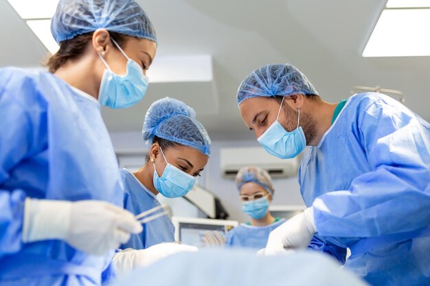 Urgent surgery Professional smart intelligent surgeons standing near the patient and performing an operation while saving his life