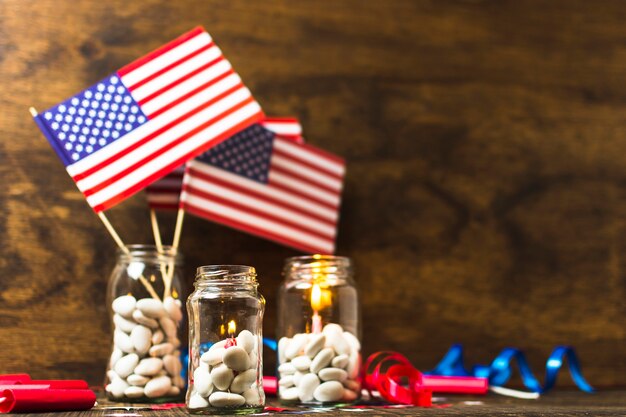 США американский флаг и зажженные свечи в банке белых конфет на деревянный стол