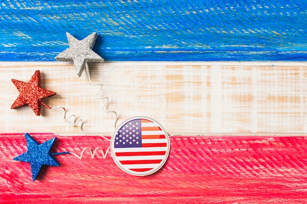 アメリカ国旗のバッジと赤と青の星塗られた木製の織り目加工の背景