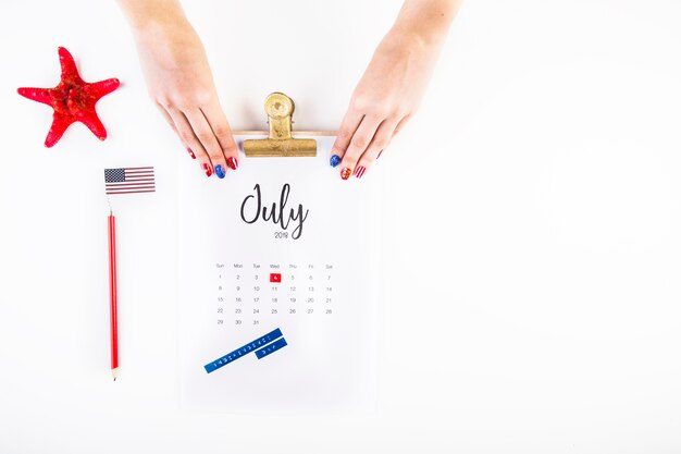 Usa independence day concept with calendar and hands above