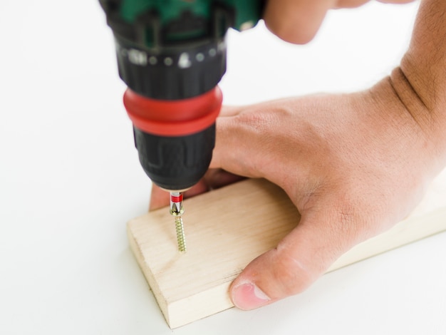 Free photo using of perforator with nozzle on wooden bar