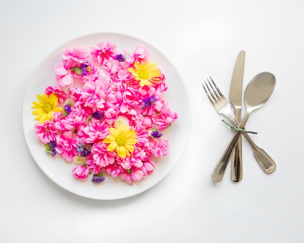 Посуда возле милых цветов на тарелке
