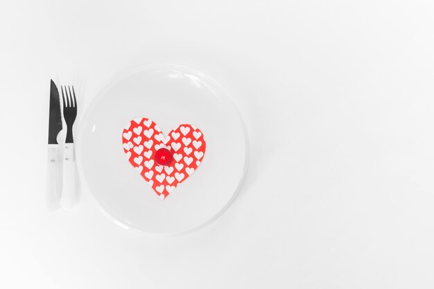 Utensils near plate with heart