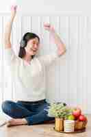Free photo vacation moment with beautiful asian woman enjoy listening music headphone with peaceful and happiness white room interior background
