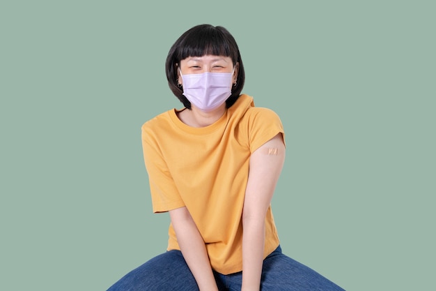 Free photo vaccinated asian woman presenting shoulder