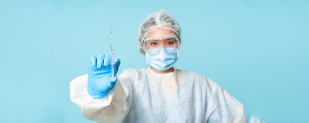 Бесплатное фото Вакцинация и коварная концепция медицинского работника азиатский врач показывает вакцину против коронавируса в шприце