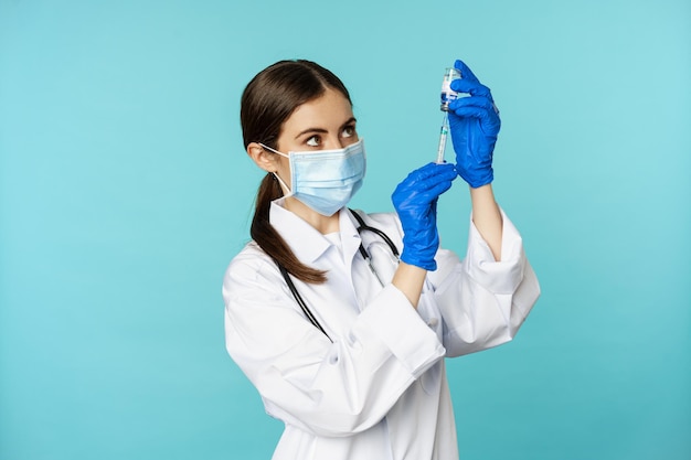 Vaccination from covid and healthcare concept young woman doctor nurse in face mask and gloves using...