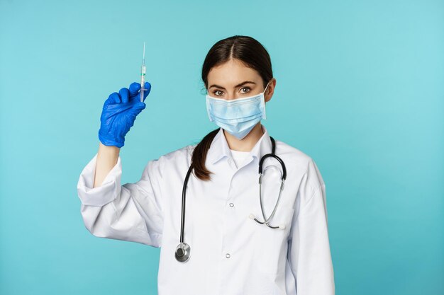 Vaccination from covid and healthcare concept young woman doctor nurse in face mask and gloves using...