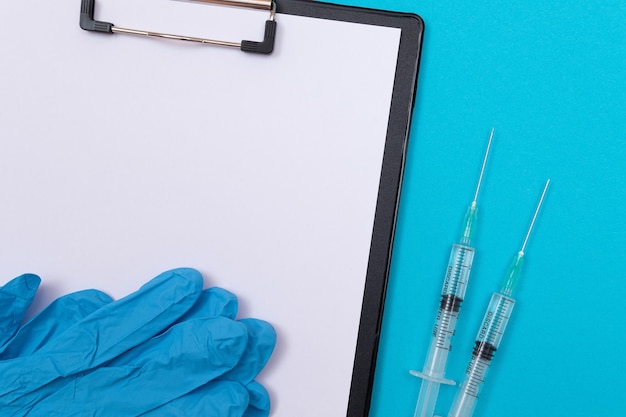 Концепция вакцинации или ревакцинации два медицинских шприца на синем столе