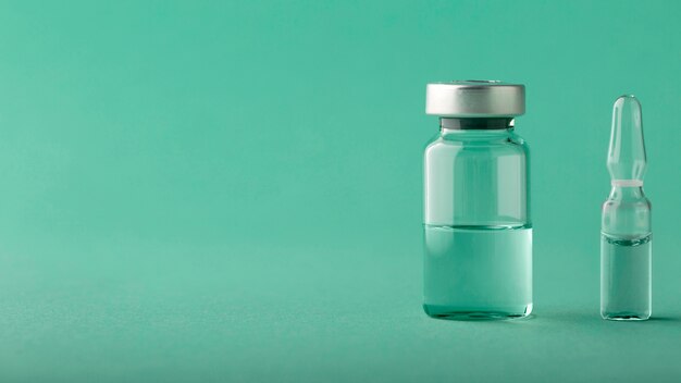 Расположение бутылок с вакциной на зеленом
