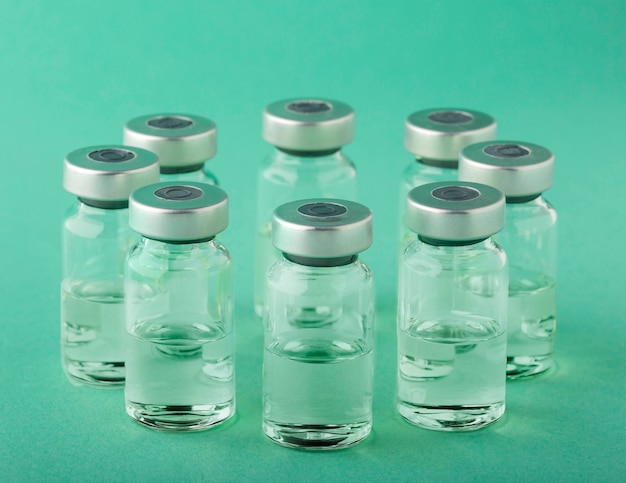 Free photo vaccine bottle arrangement on green