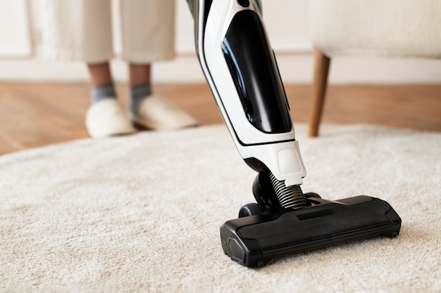 Free photo vacuum cleaning a rug on the floor