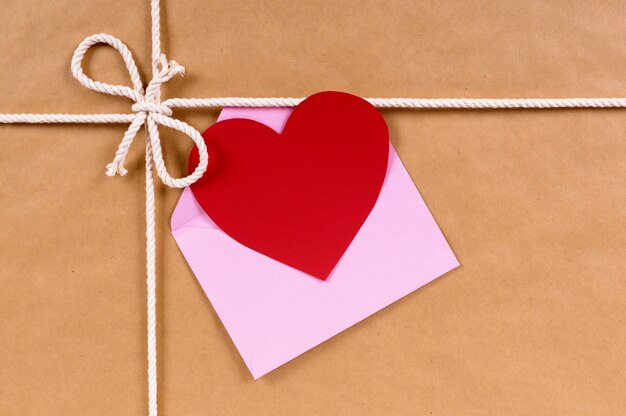 Valentine card on a brown paper package or gift tied with string.