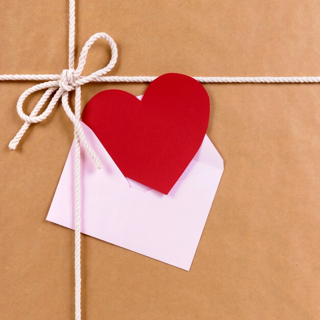 Valentine gift with red heart card or gift tag, brown paper package