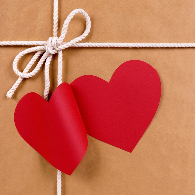 赤いハート形のギフトタグ、茶色の紙のパッケージとバレンタインギフト