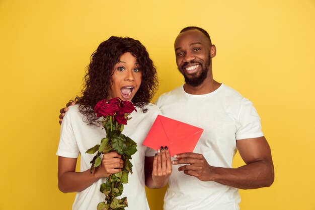 Free photo valentine's day celebration, happy african-american couple isolated on yellow