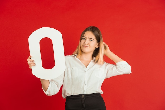 Valentine's day celebration, happy, cute caucasian girl holding letter on red studio