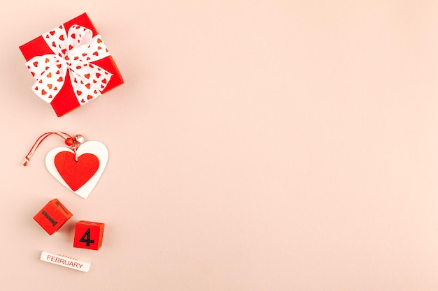 Composizione di san valentino con confezione regalo, cuori e nastro su sfondo calming coral. disposizione piatta, copia spazio. mockup di biglietto di auguri per san valentino.