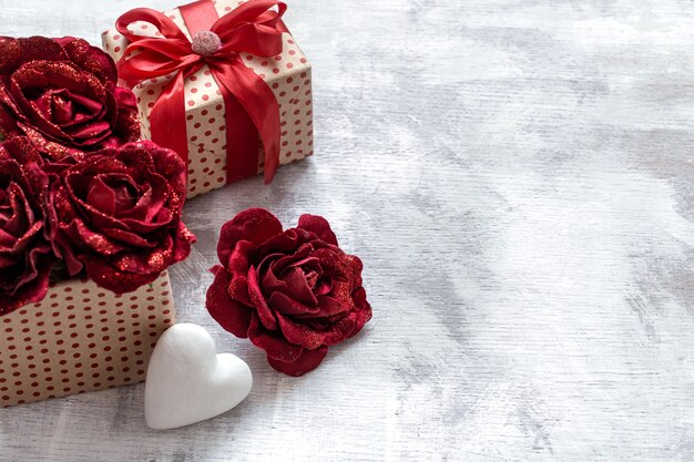 Valentine's day gift with decorative roses and white heart on light background copy space.